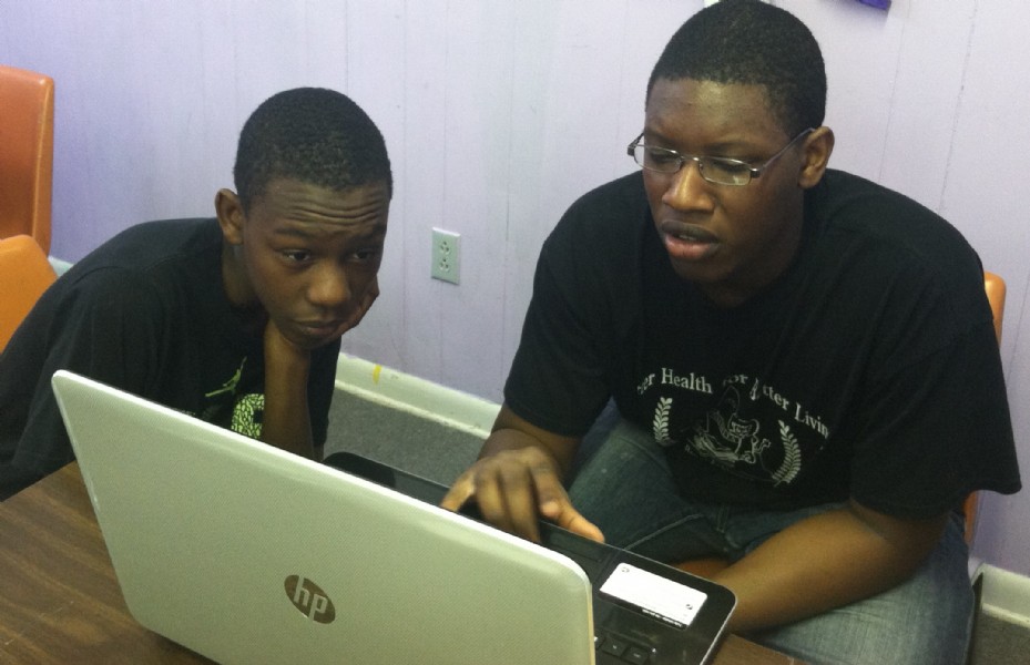 Two boys looking at a laptop