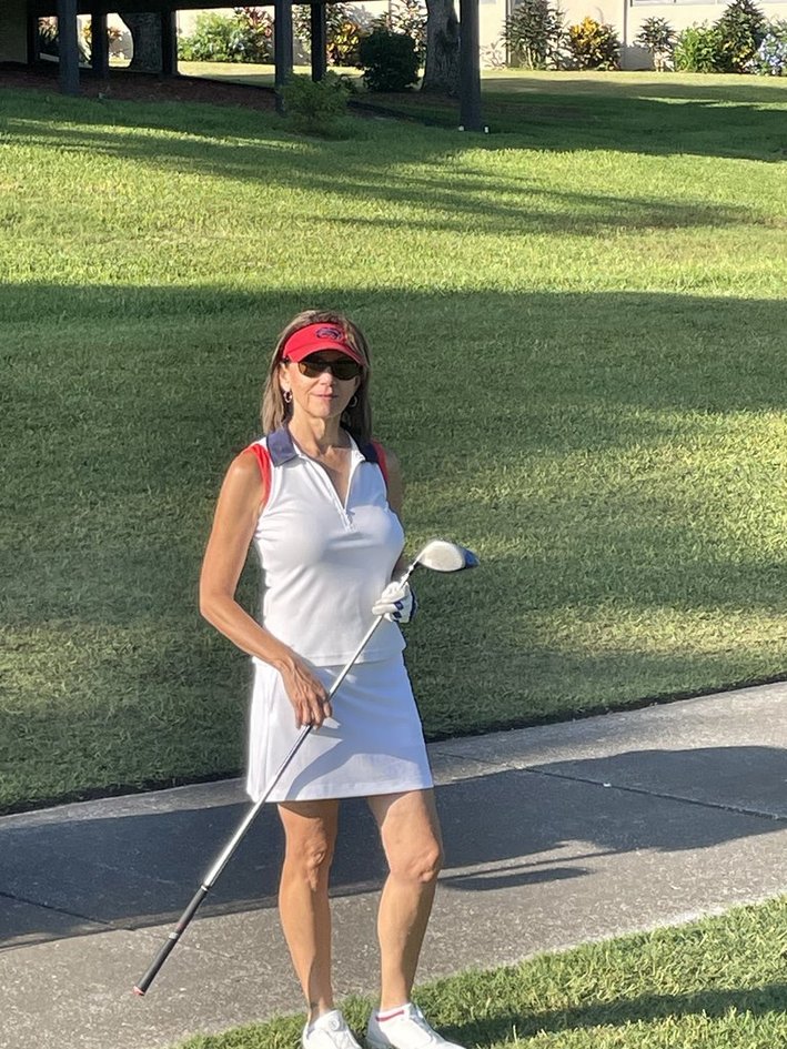 female golfer dressed in white and red