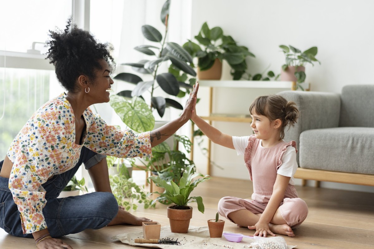 A mother and child sharing a high-five during a moment of celebration at home.